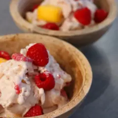 Två skålar med krämig glass, toppad med hallon och mangobitar. Ett perfekt proteinglass recept för en varm sommardag.