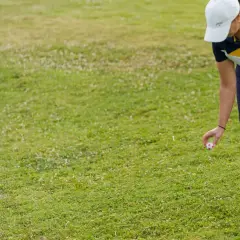 En golfare placerar bollen för ett korrekt dropp.