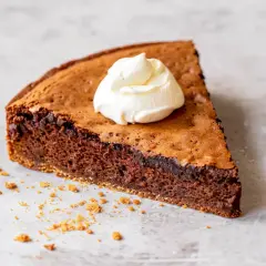 En bit kladdig protein kladdkaka med en klick vispad grädde.