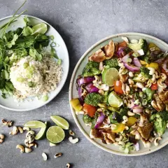 Två tallrikar med mat. En med ris, koriander och lime. Den andra med kyckling, broccoli, paprika, lök, cashewnötter och lime – en fest av nyttiga råvaror.