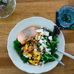 Laxskål med krispig grönkål, frukt, nötter och ost. En hälsosam måltid med cirka 30g protein.