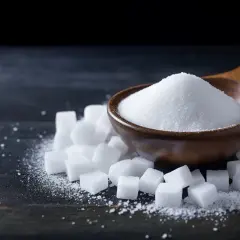 En träsked fylld med socker, omgiven av sockerbitar. Ett alternativ för dem med diabetes, som erytritol.