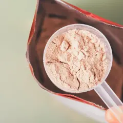 En skopa proteinpulver tas ur en påse. Frågan är om man går upp i vikt av proteinpulver.