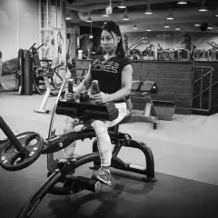 Kvinna tränar sittande vadpress på gym.