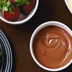 En skål med krämig sockerfri chokladsås, perfekt för att doppa färska jordgubbar.