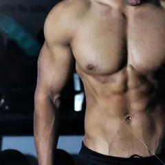 Muskulös man i gym, med fokus på magmuskler och armar. Bra inspiration för viktnedgång tips och träning.