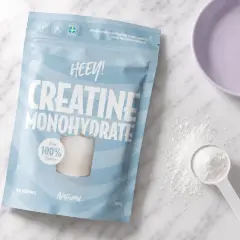 Påse med HEEY! Kreatin Monohydrat, perfekt för kreatin laddning. Pulver och skopa syns bredvid.