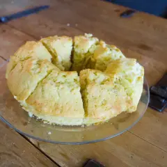 En saftig sockerkaka, uppskuren i bitar, ligger på ett fat på ett träbord.