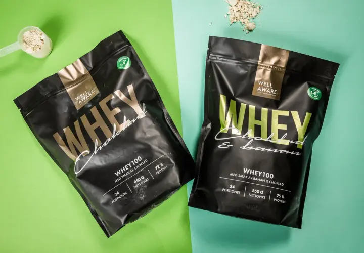 Två påsar Well Aware Whey100, en med chokladsmak och en med banan & choklad. Jämför whey 100 vs 80 för din träning.