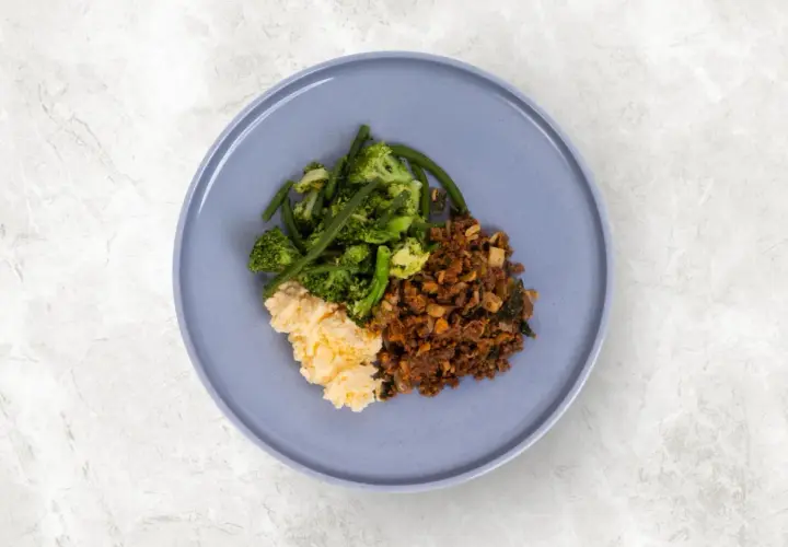En tallrik med mat utan kolhydrater och socker: äggröra, broccoli med gröna bönor och köttfärs.
