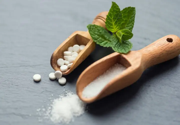 Två träskopor med socker och stevia-tabletter. Är stevia farligt? Frågan kvarstår.