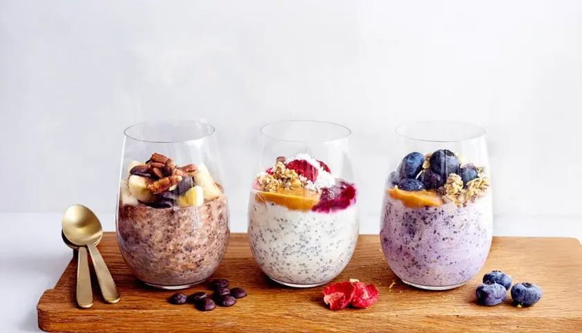Tre glas med overnight oats choklad, blåbär och banan. Perfekt frukost eller mellanmål.