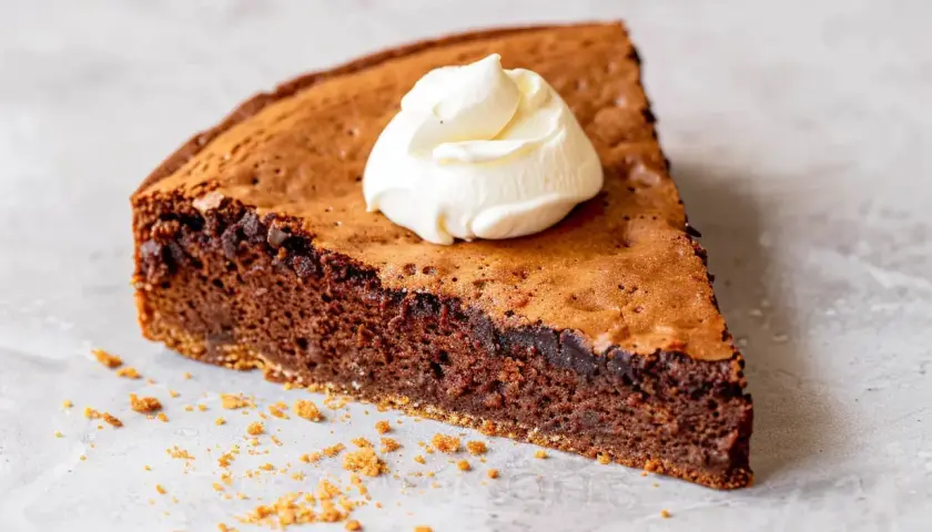 En bit kladdig protein kladdkaka med en klick vispad grädde.