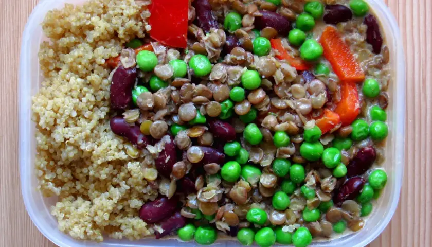 Här är en matlåda med quinoa, linser, gröna ärtor, kidneybönor och röd paprika. Perfekt för en näringsrik lunch.