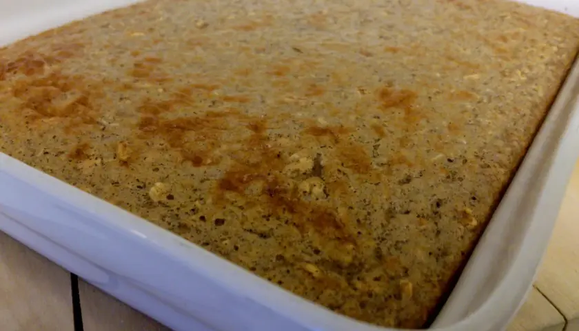 En gyllene protein ugnspannkaka i en vit form, redo att serveras.