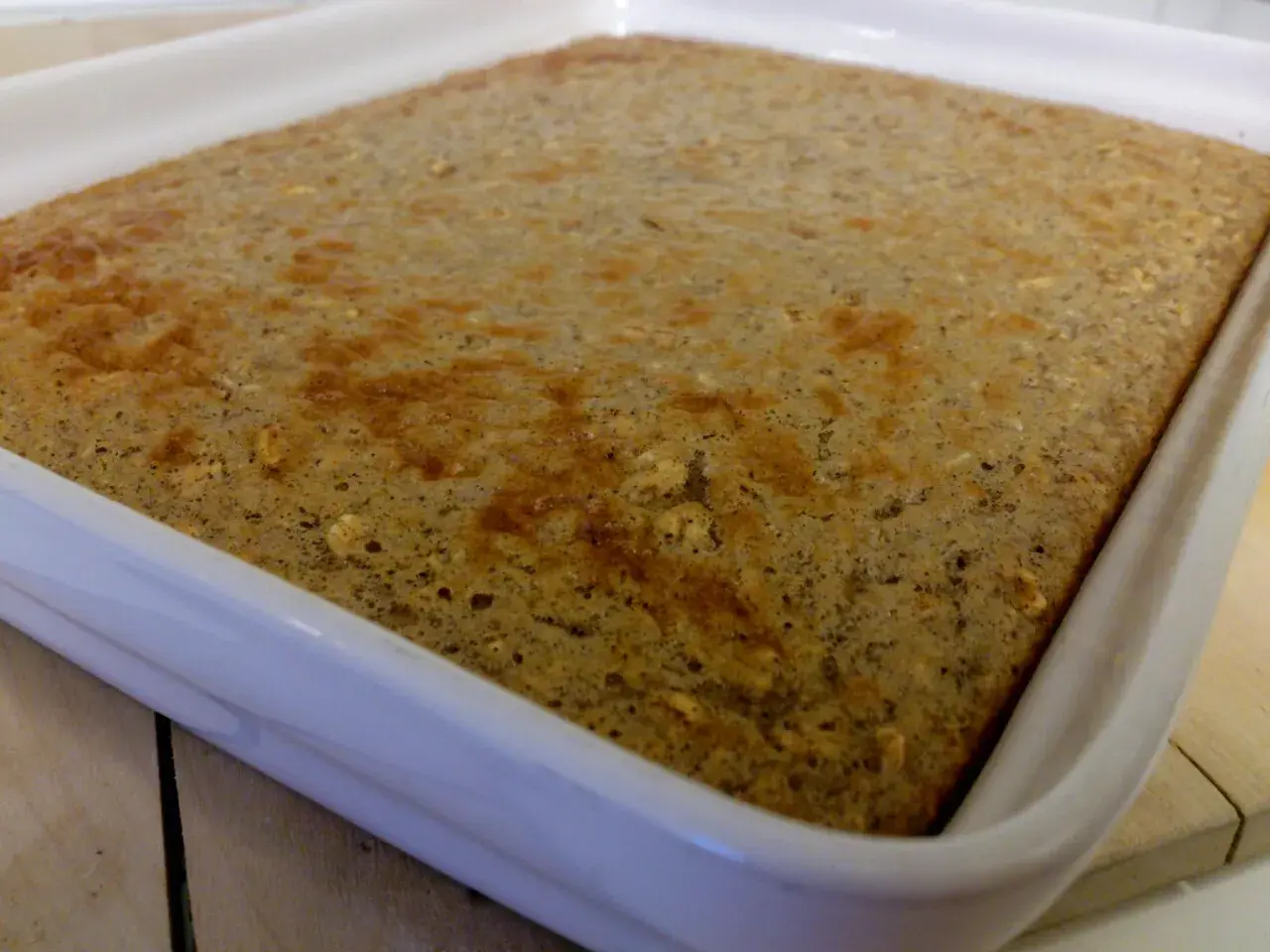 En gyllene protein ugnspannkaka i en vit form, redo att serveras.