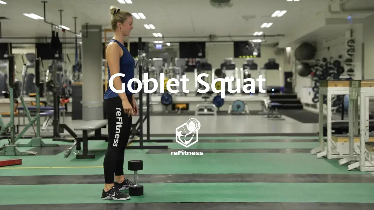 Kvinna förbereder sig för en goblet squat med en hantel i ett gym.