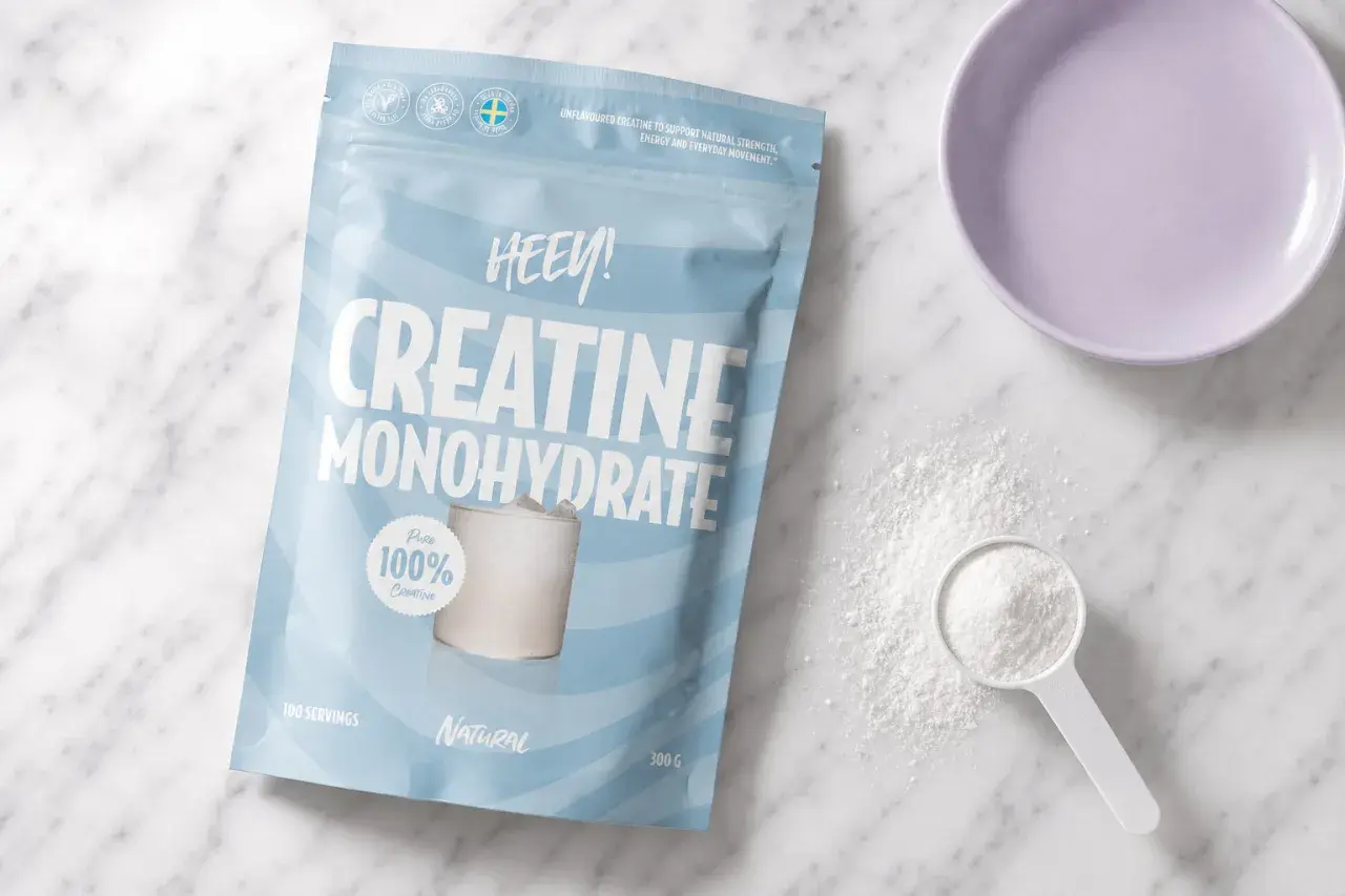 Påse med HEEY! Kreatin Monohydrat, perfekt för kreatin laddning. Pulver och skopa syns bredvid.