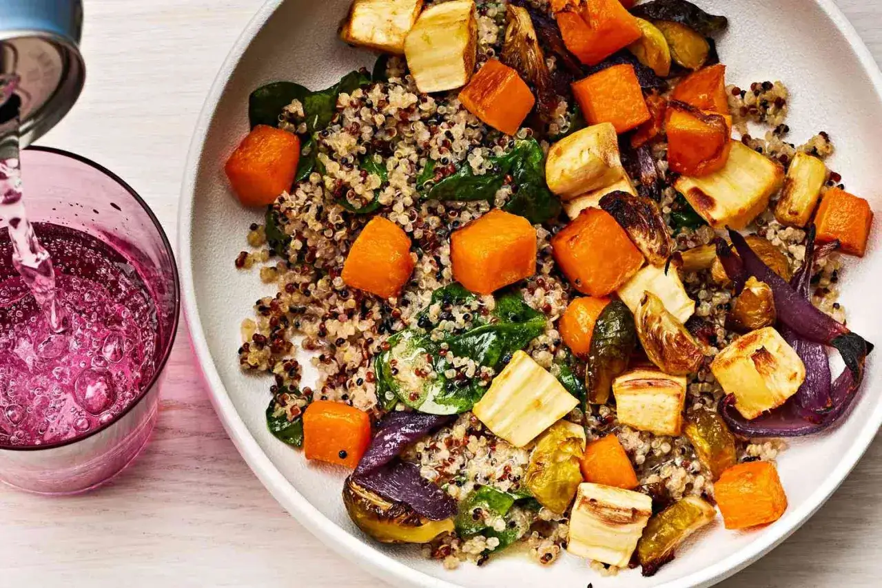 En sk&aring;l med quinoa, rostade gr&ouml;nsaker som pumpa och palsternacka, samt spenat. En drink h&auml;lls upp i ett glas bredvid. En n&auml;ringsrik m&aring;ltid med bra protein per kg.