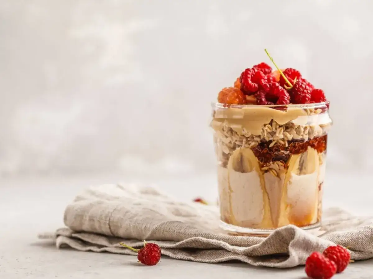 En läcker proteinpudding i glasburk med banan, havre, jordnötssmör och hallon. Ett perfekt proteinpudding recept för frukost eller mellanmål.