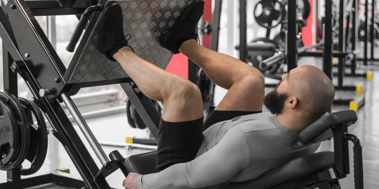 Man tränar ben på en benpress. En del av push pull legs-träningen.