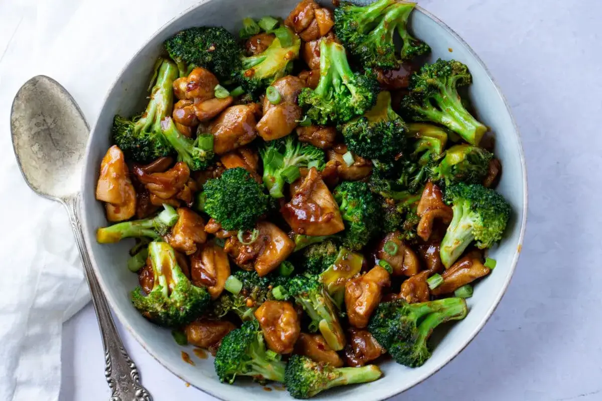 En skål med kyckling och broccoli i en glansig sås. En hälsosam måltid utan kolhydrater och socker, perfekt för en snabb middag.