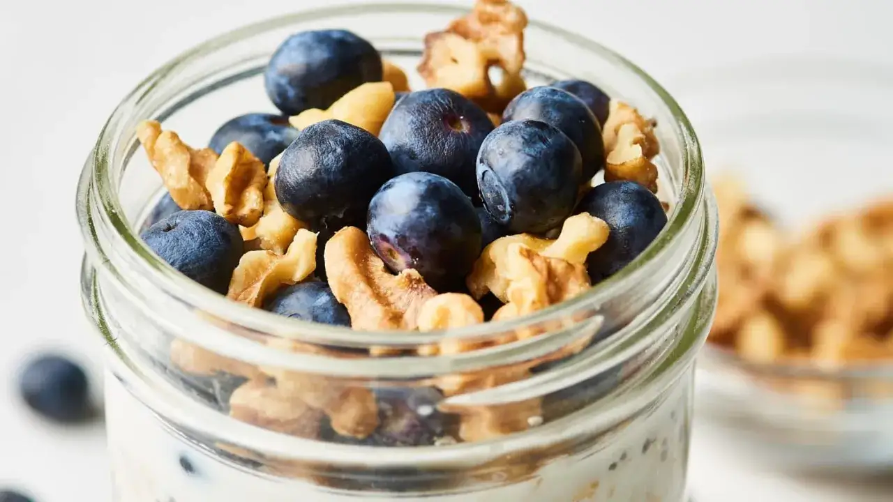 En burk med overnight oats recept, toppad med blåbär och valnötter. En perfekt start på dagen!